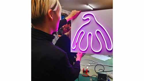 A person holds up an LED neon light sign