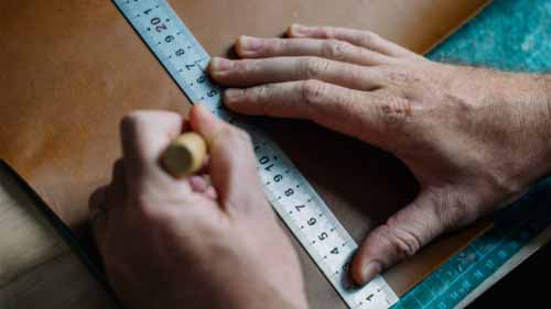 A person measuring a board